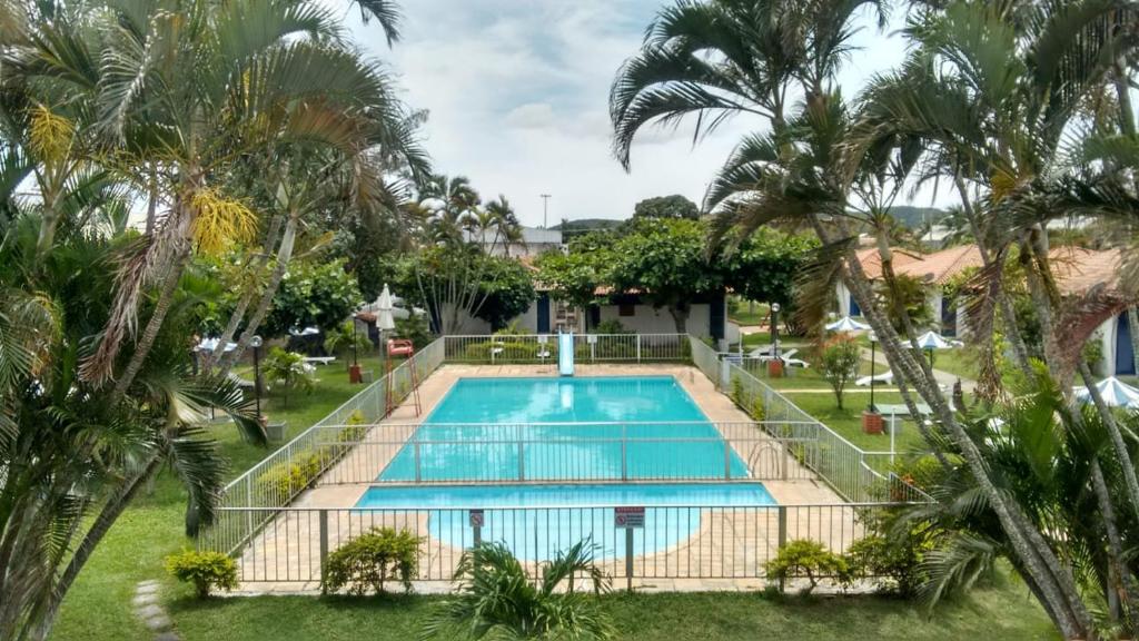 uma piscina num resort com palmeiras em Flat Bangalô 103 em Cabo Frio