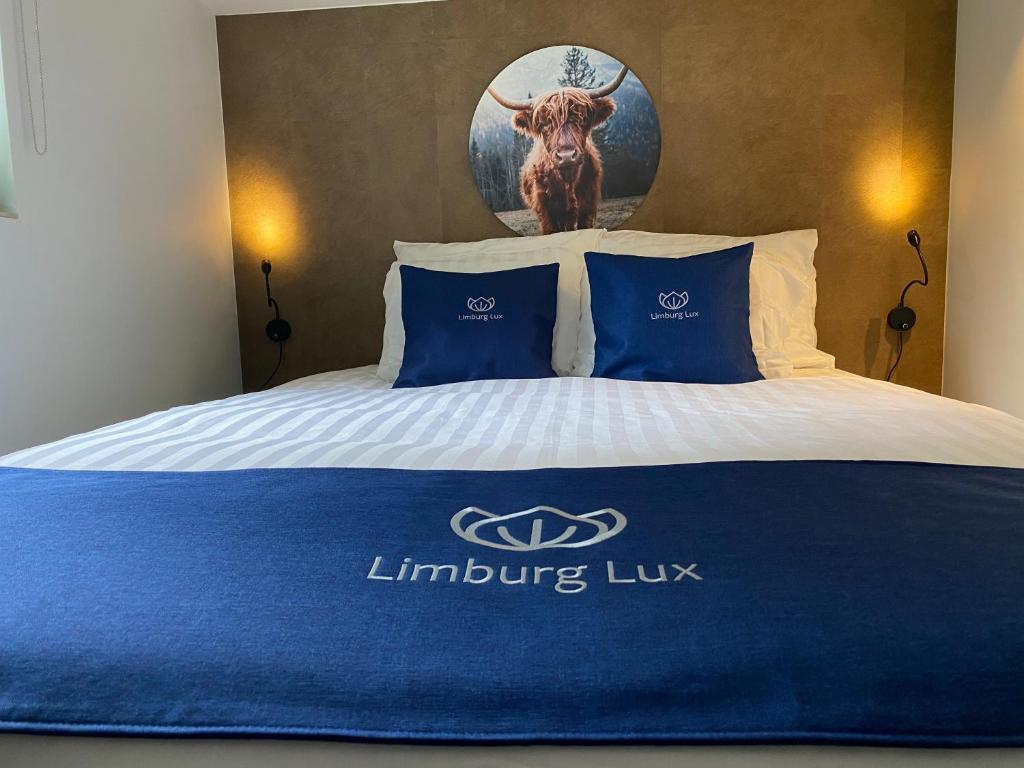 uma cama com um cobertor azul e branco em Limburg Lux 90 em Simpelveld