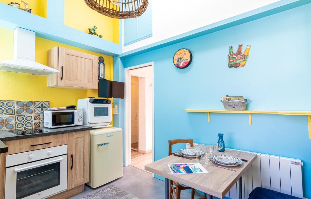 a small kitchen with a table and a microwave at Gîte La Périssoire - place de parking incluse in Étretat