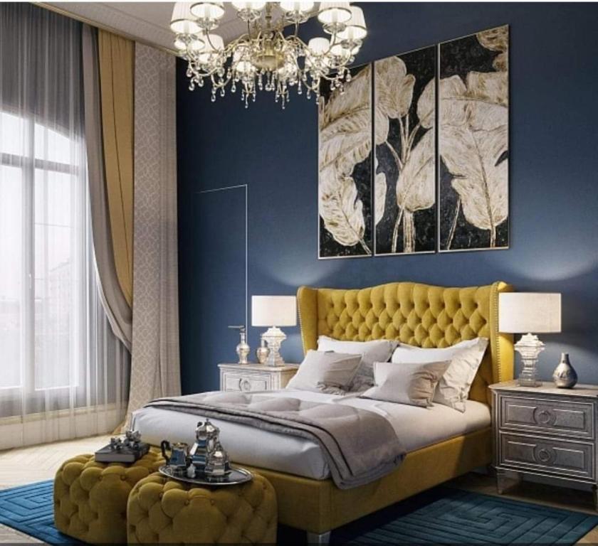 a bedroom with a yellow bed and a chandelier at Sandanski Apartments Top Center in Sandanski