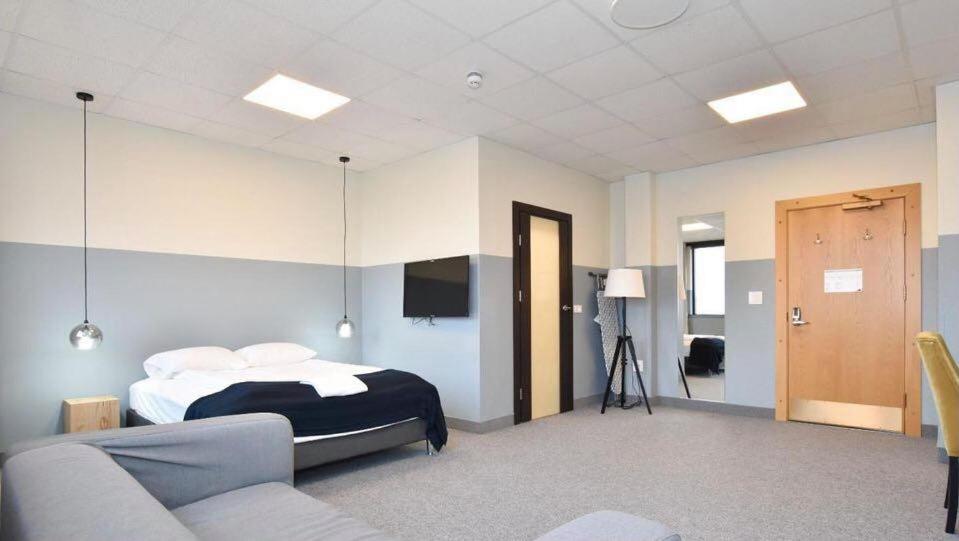 - une chambre avec un lit et un canapé dans l'établissement ABC Hotel by Reykjavik Keflavik Airport, à Keflavík
