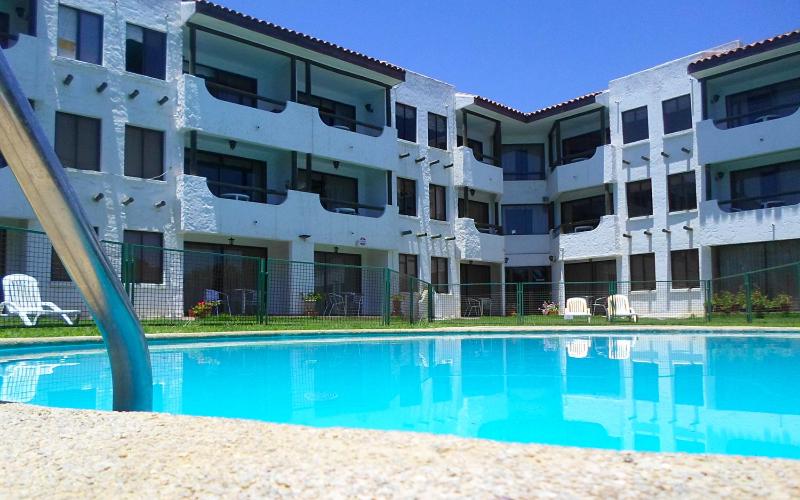 una piscina vacía frente a un edificio en Apart Hotel Sendero del Sol en La Serena