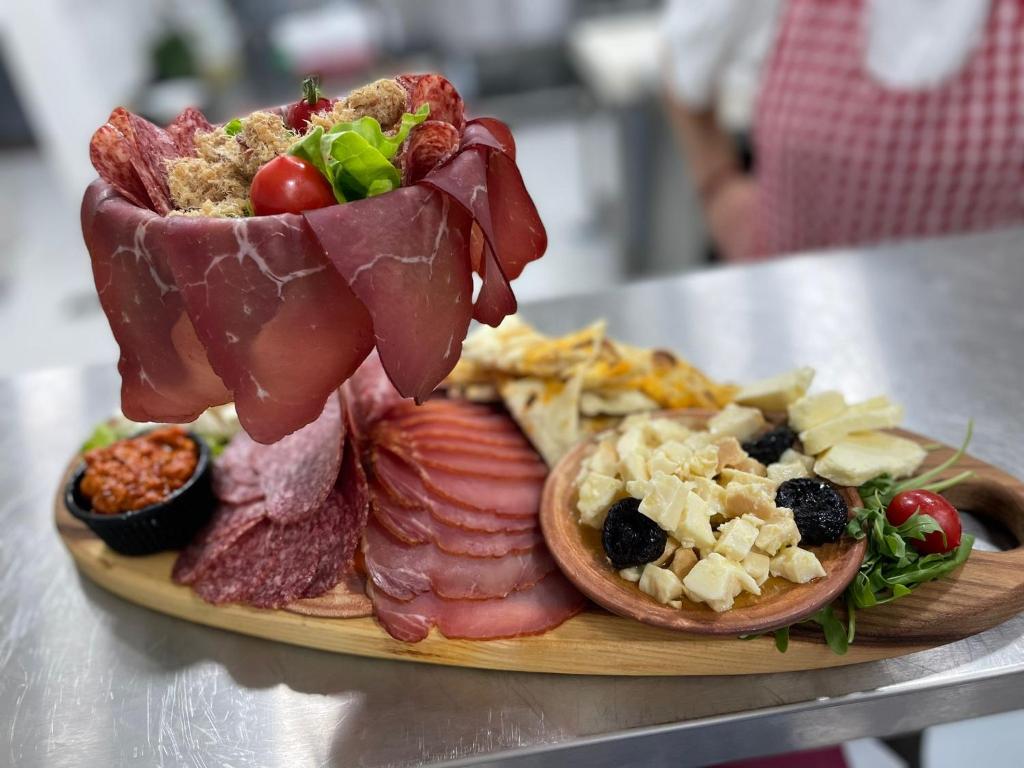 a plate of food with meat and other foods at ETNO SELO VRANEŠA Zlatar in Nova Varoš