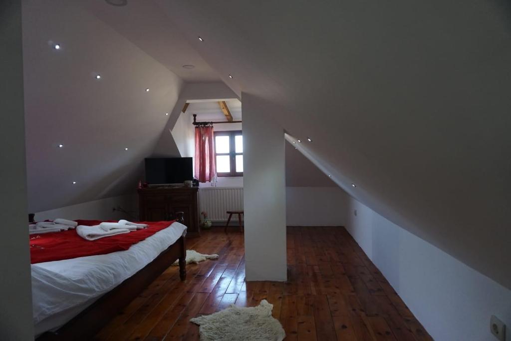 a bedroom with a bed and a staircase with a window at ETNO SELO VRANEŠA Zlatar in Nova Varoš
