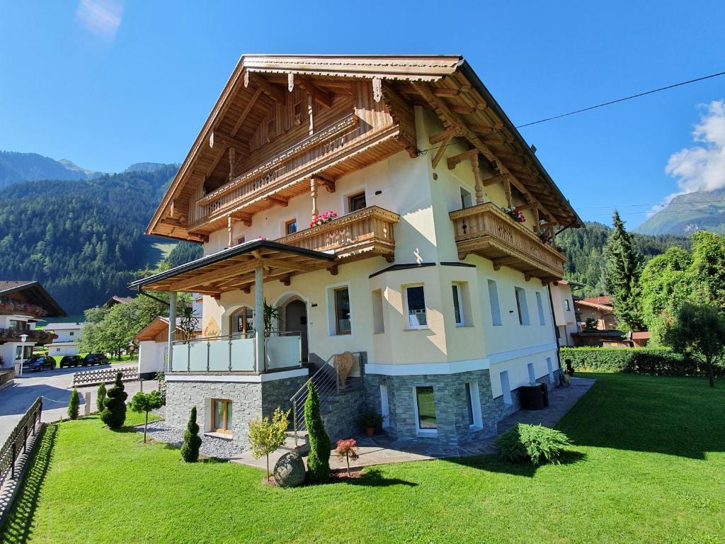 a large house with a wooden roof at Apart Edelhof in Mayrhofen