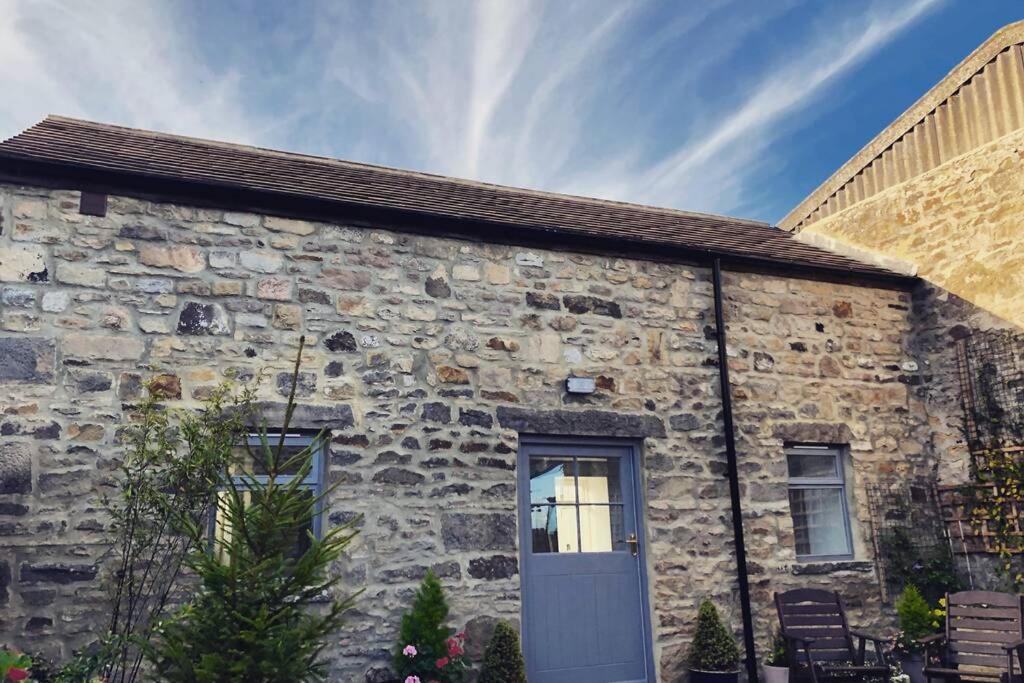 um edifício de pedra com uma porta ao lado em Phil's Cottage Sleeps 2 one dog by prior permission em Barnard Castle