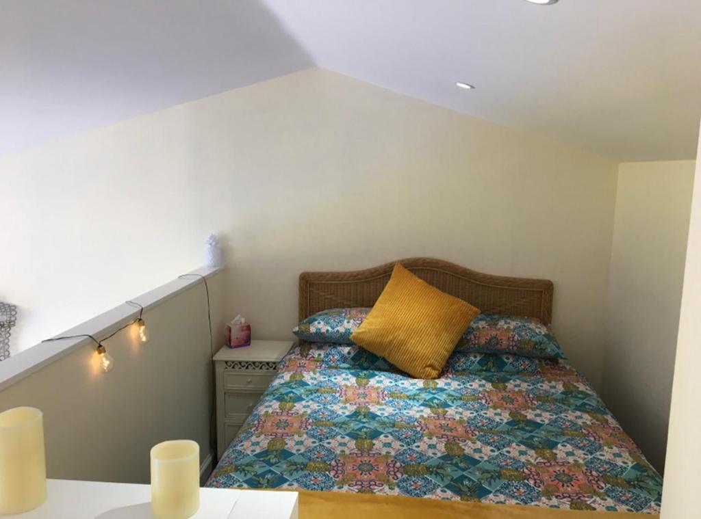 a small bedroom with a bed with a yellow pillow at The Croft Accommodation in Gamrie