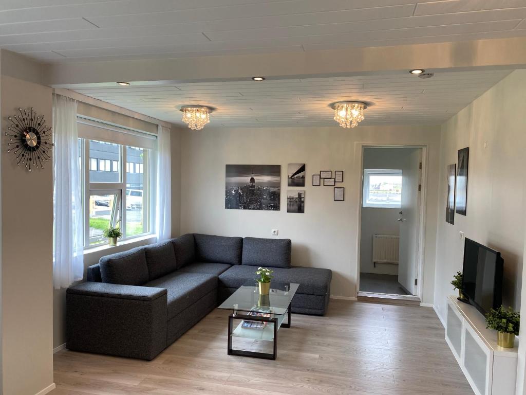 a living room with a couch and a tv at Sol apartment in Keflavík