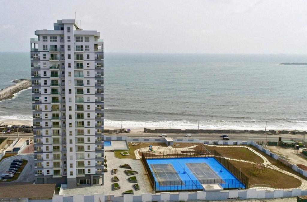 a tall building with a swimming pool next to the ocean at Oceanview Smart Home with Pool in Oniru-Lekki 1 in Lekki