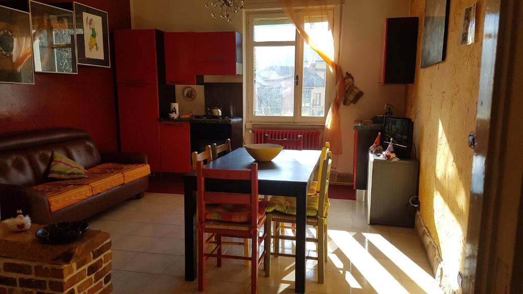cocina con mesa, sillas y sofá en Coccole&Bollicine, en Bérgamo
