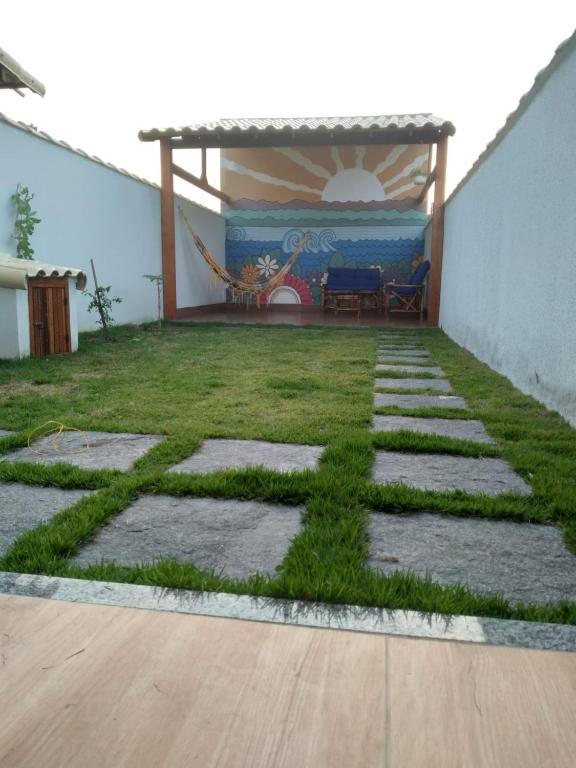 a garden with grass on the ground next to a building at Casa com Jardim na Praia de Guaratiba, Maricá in Maricá