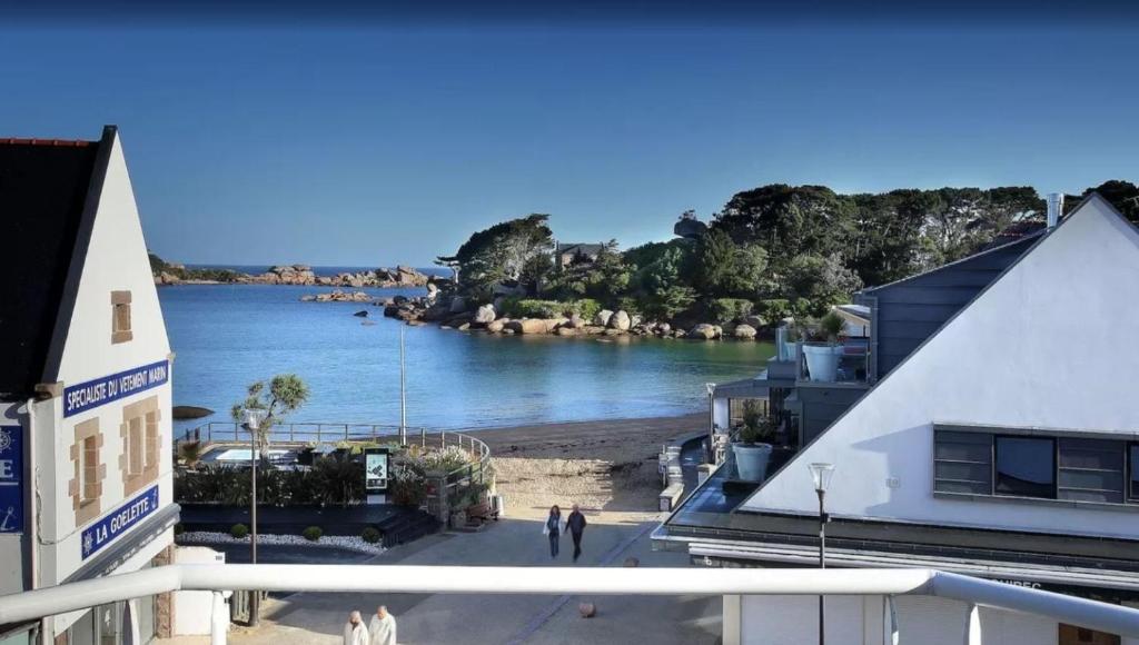 - une vue sur une étendue d'eau avec des personnes se promenant sur la plage dans l'établissement Hotel De L'Europe, à Perros-Guirec