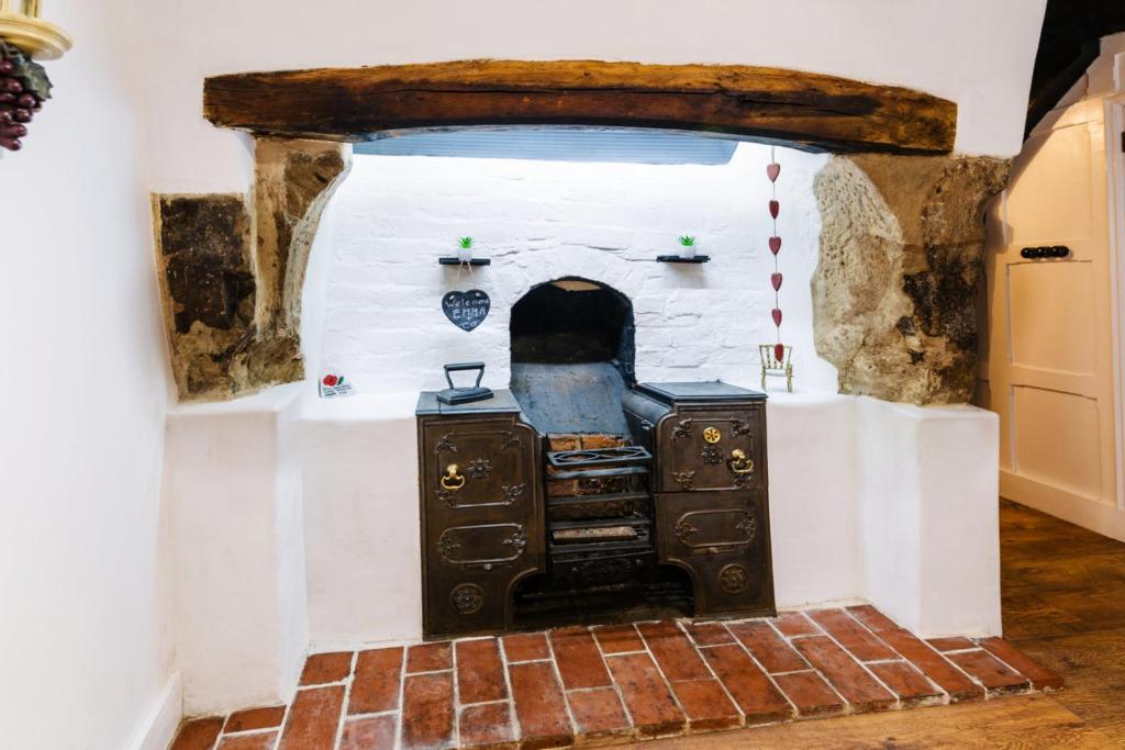 un horno en una habitación con suelo de ladrillo en "Wesley House" Historic home in town Centre with Parking en Shrewsbury