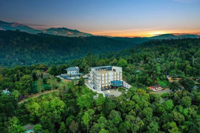 an aerial view of a building in the middle of a forest at Lemongrass inn munnar in Anachal