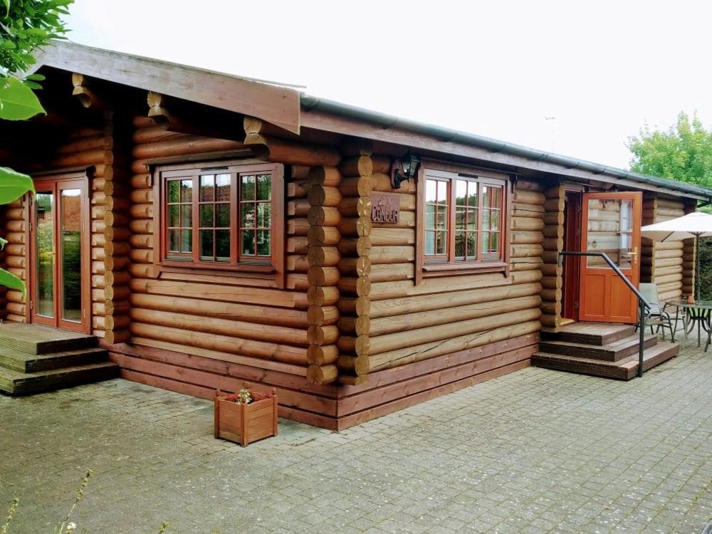 Cabaña de madera con porche y patio en Osiers Country Lodges, en Diss