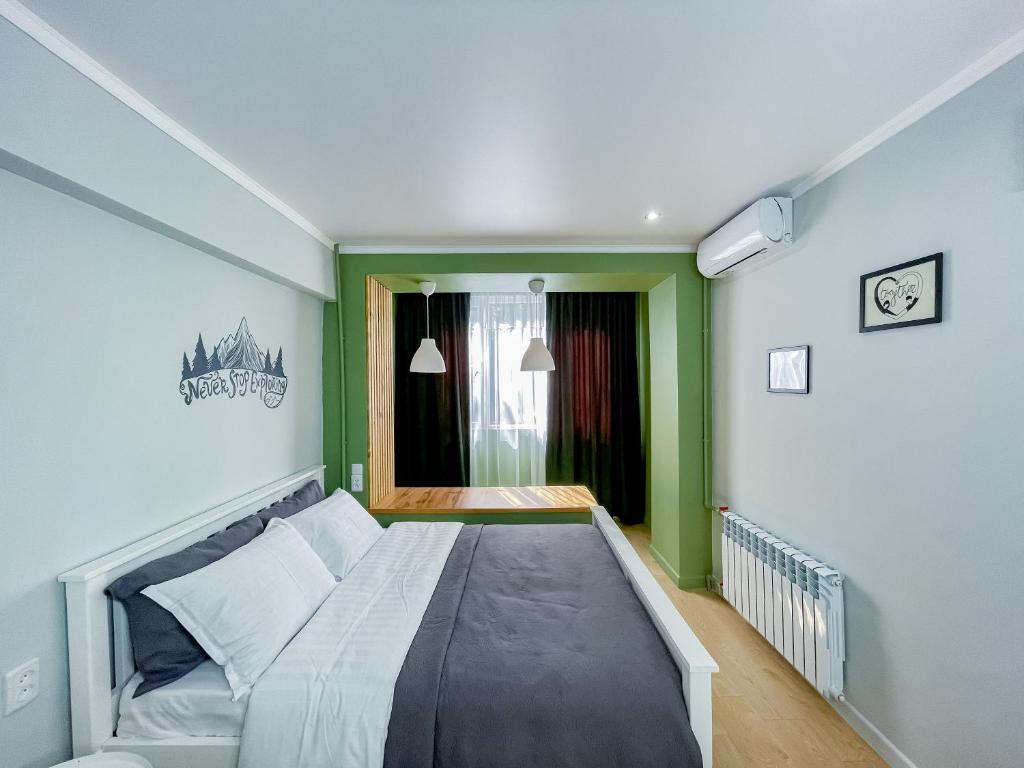 a bed in a room with green and white at Evergreen Apart in Almaty