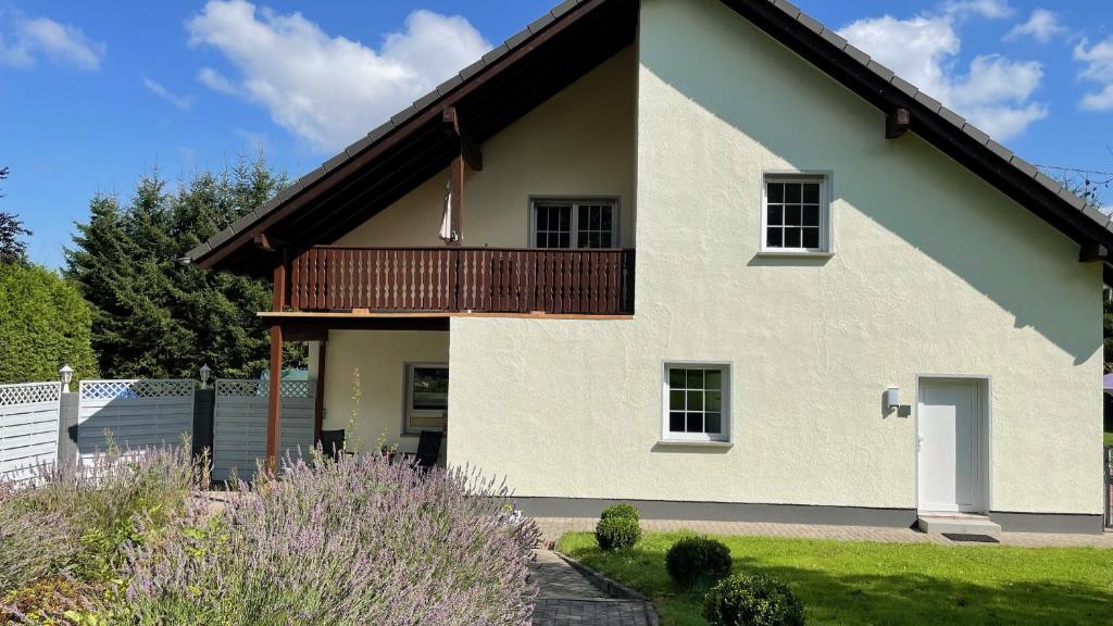 Cette maison blanche dispose d'un balcon en bois. dans l'établissement Haus Kristal, à Walsdorf