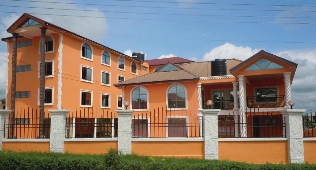 un edificio naranja con una valla delante en SWATSON HOTEL, en Kumasi