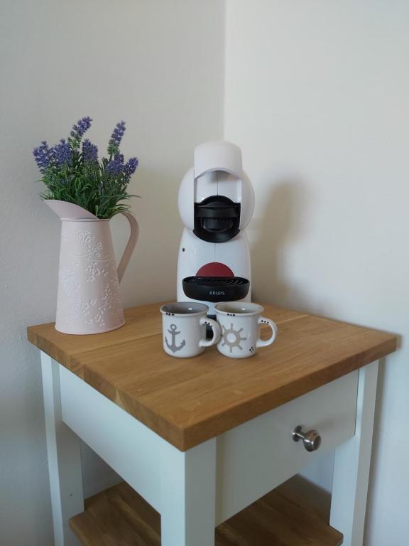 a table with two coffee mugs and a coffee maker at Apartmán Tony Slapy in Slapy