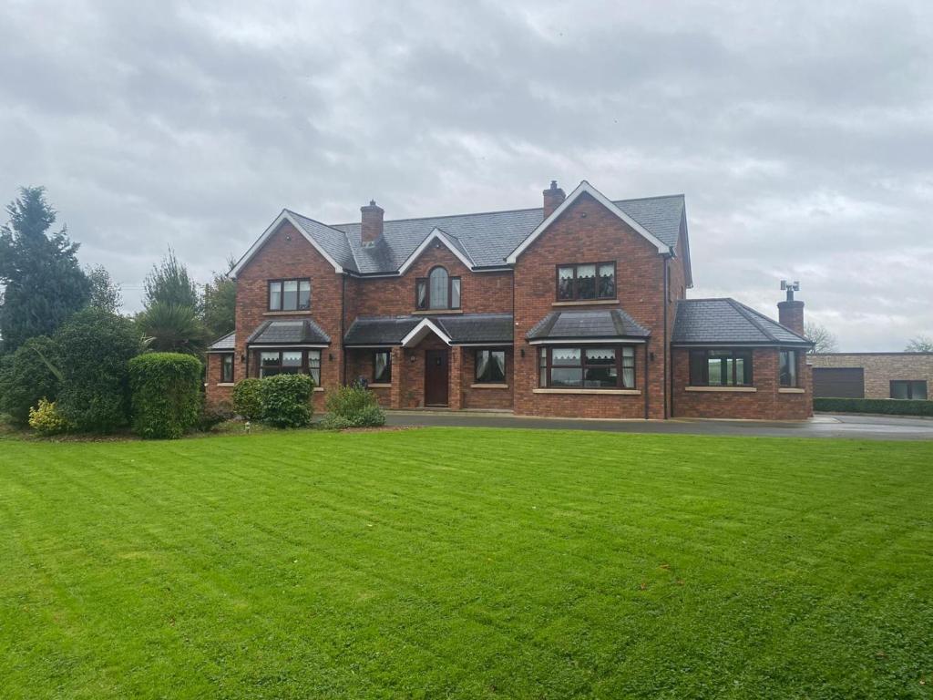 a large brick house with a large green lawn at Gallagh Guest House self catering h18r252 Eircode in Monaghan