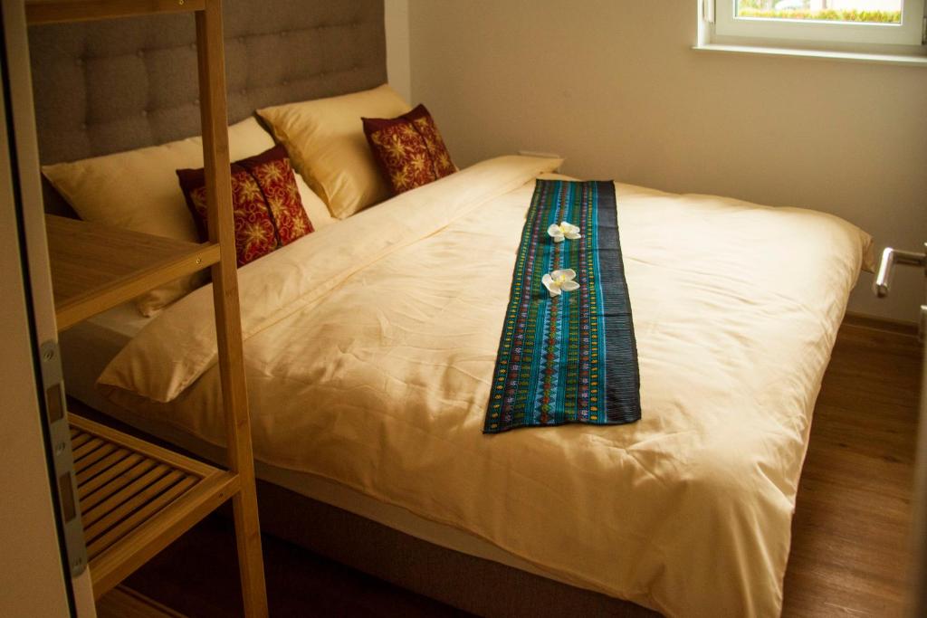 a white bed with a tie on top of it at Chang Thai apartments in Ljubljana