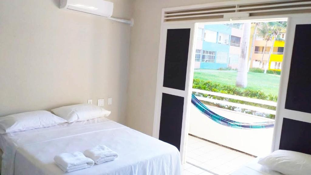 - une chambre avec un lit et une grande fenêtre dans l'établissement Frente a Praia Aconchegante, à Fortaleza