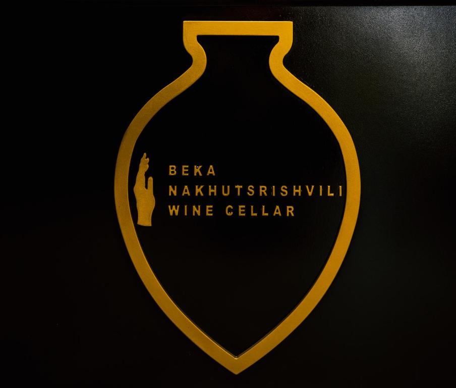um vaso amarelo com uma etiqueta num fundo preto em Bekas wine cellar em Akhmeta