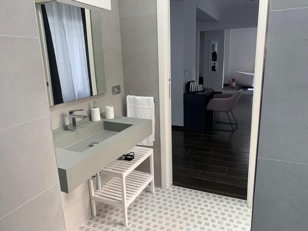 łazienka z umywalką i lustrem w obiekcie Argiro95 Luxury w mieście Bari