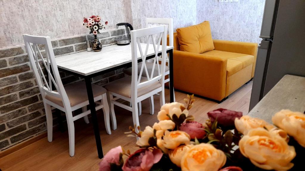eine Küche mit einem Tisch, Stühlen und einem Sofa in der Unterkunft Yellow Apartment in Tbilisi City