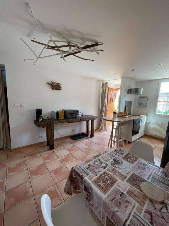 ein Wohnzimmer mit einem Tisch und einer Küche in der Unterkunft Le Bois Flotté in Arrigny