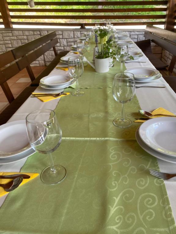 a long table with plates and wine glasses on it at apartma fortuna kmečki hram in Idrija
