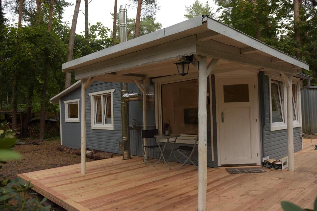 a blue tiny house with a roof on a wooden deck at Allerlichtung in Buchholz Aller