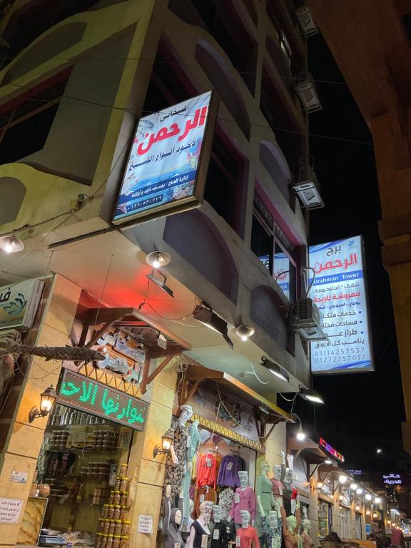 un magasin avec des panneaux sur le côté d'un bâtiment dans l'établissement ALRahman Building, à Assouan