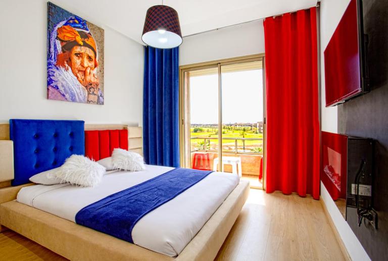 1 dormitorio con 1 cama grande y cortinas azules y rojas en Privilege House jade, en Marrakech