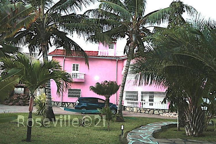 a pink house with a car parked in front of it at Roseville in Diani Beach