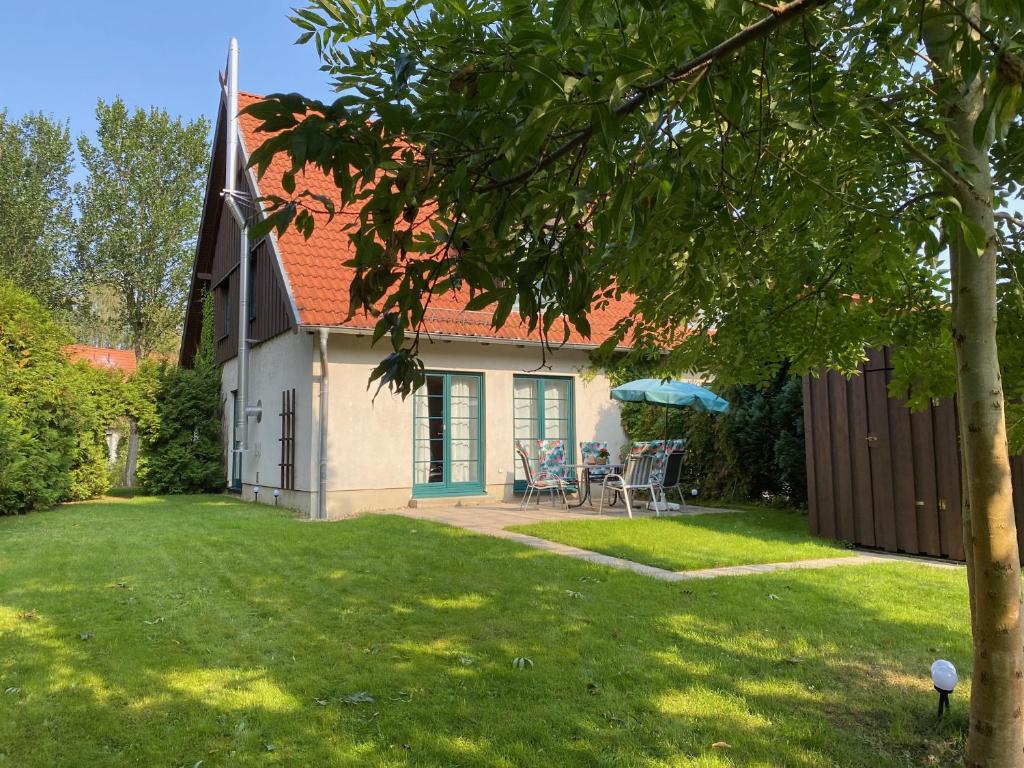 een klein wit huis met een tafel en stoelen in een tuin bij Ferienhaus Hase in Burg
