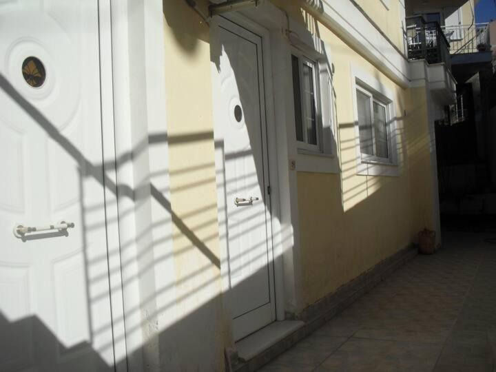 a white door on a building with a window at Ανεξάρτητο studio κοντά στο κέντρο της Πάτρας. in Patra