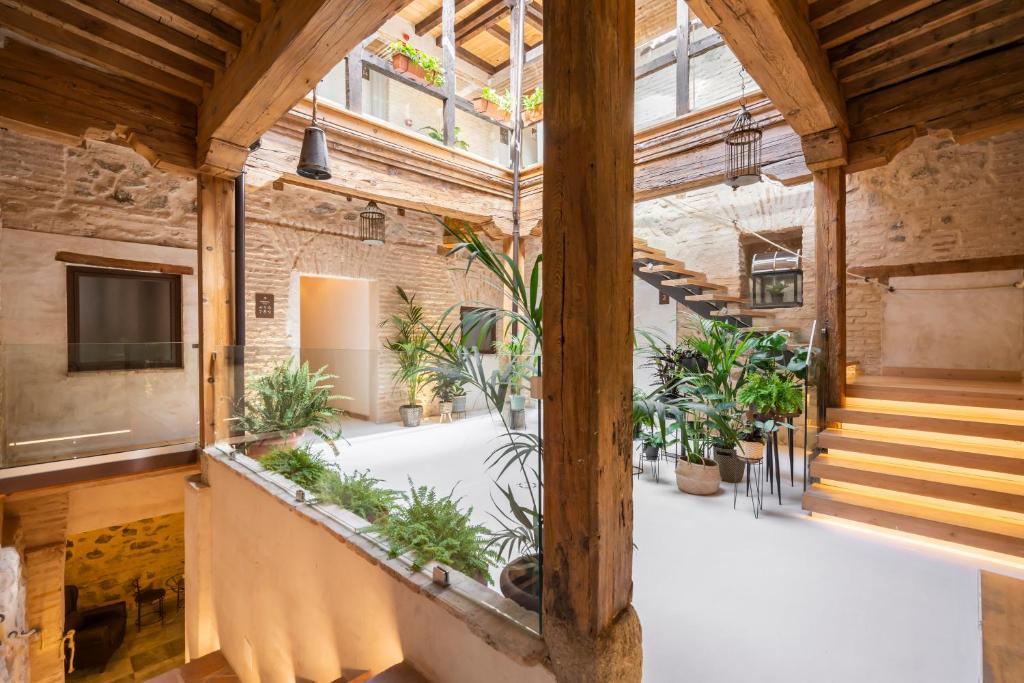 an indoor courtyard with plants in a building at Azacanes Hostal Boutique Toledo in Toledo