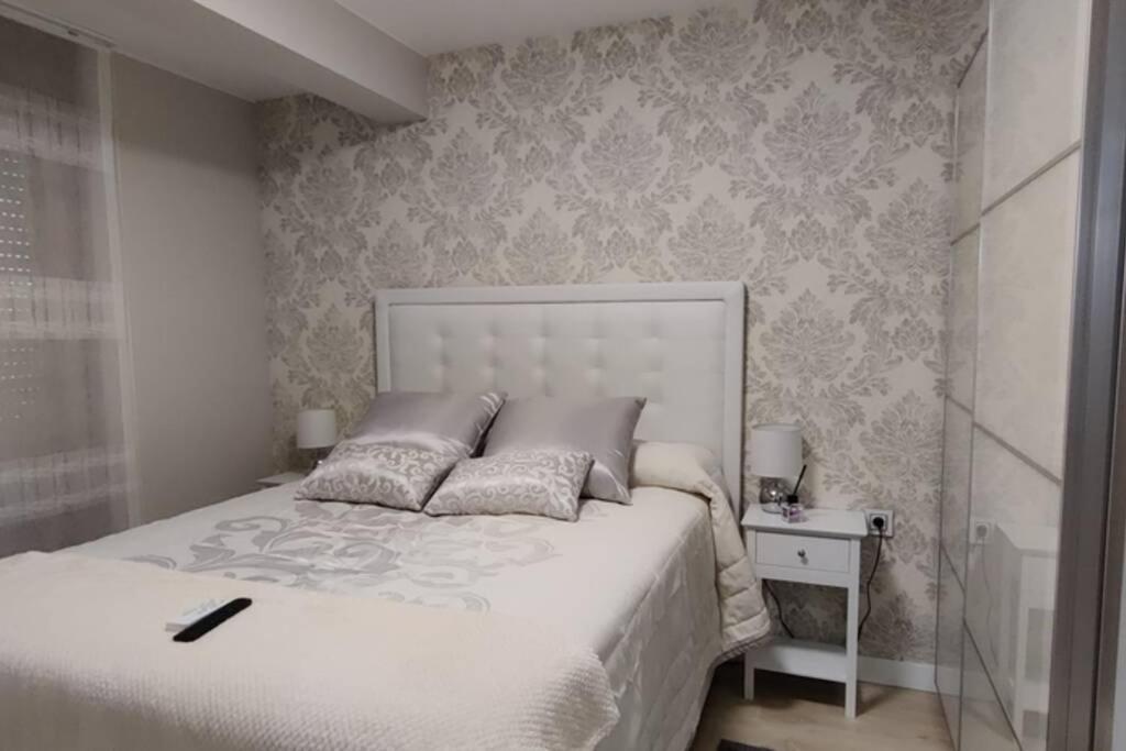 a bedroom with a large white bed and a side table at Los Sitios in Astorga