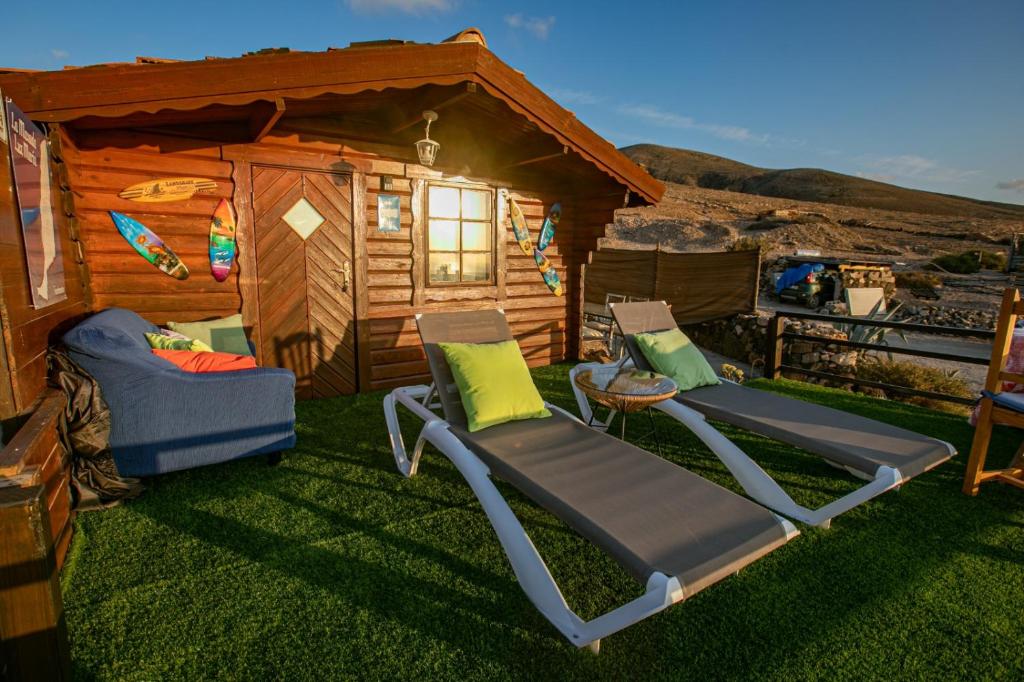 a cabin with two lounge chairs and a house at La Maxada Luz Maria in Cotillo