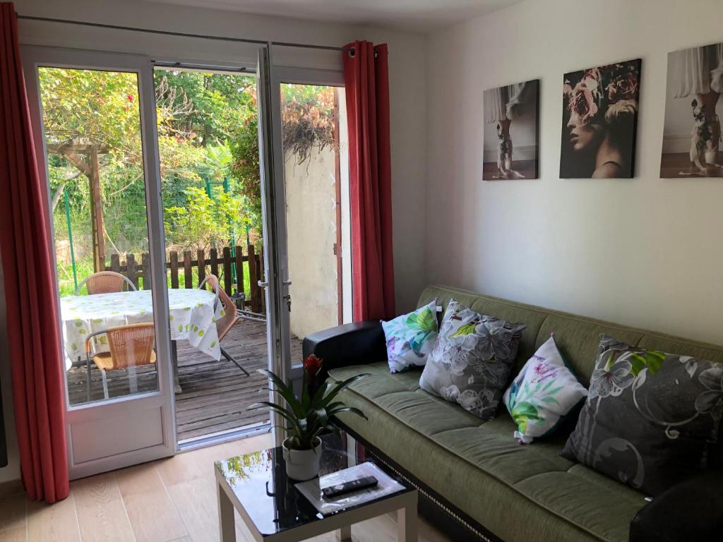 a living room with a couch and a sliding glass door at F2 avec terrasse in Saint-Denis