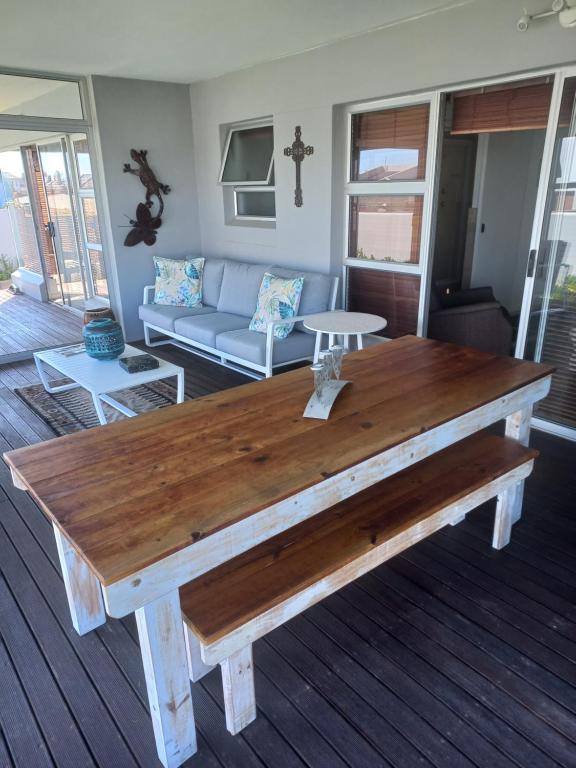 a wooden table in a living room with a couch at 86 On Babiana in Langebaan