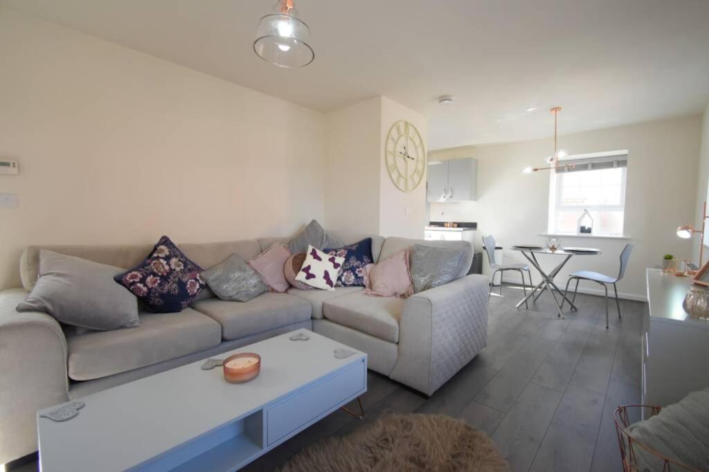 a living room with a couch and a table at The Coach House in Kirby Muxloe