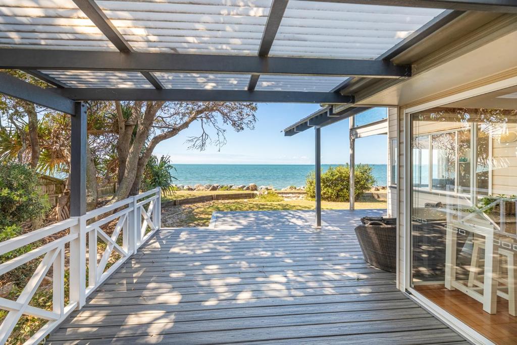 a wooden porch with a view of the ocean at Ocean Pearl - 3 bedroom beachfront property! in Beachmere