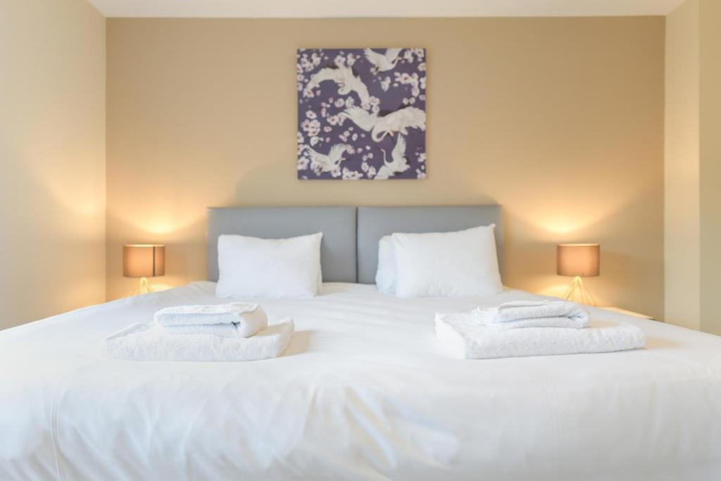 een slaapkamer met een groot wit bed met 2 kussens bij Stunning Garden House with Free WIFI and Parking in Bingham