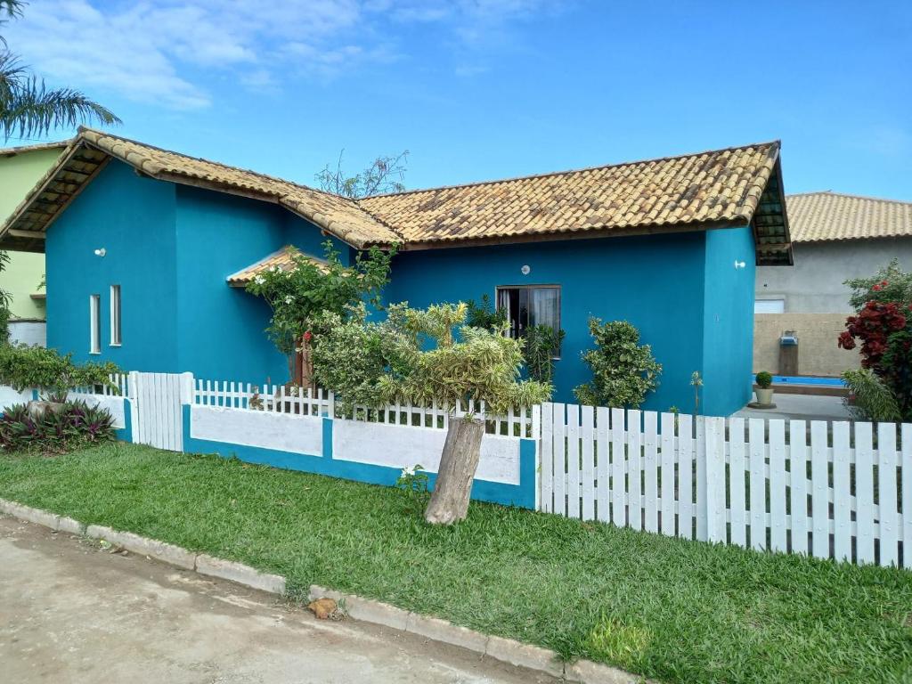 a blue house with a white fence at Vivamar2 in Cabo Frio