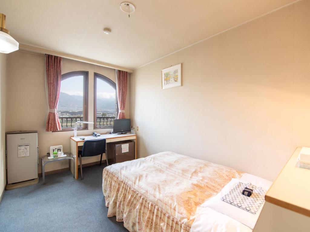 Postel nebo postele na pokoji v ubytování Tabist Hotel Sun Plaza Fuefuki Isawa