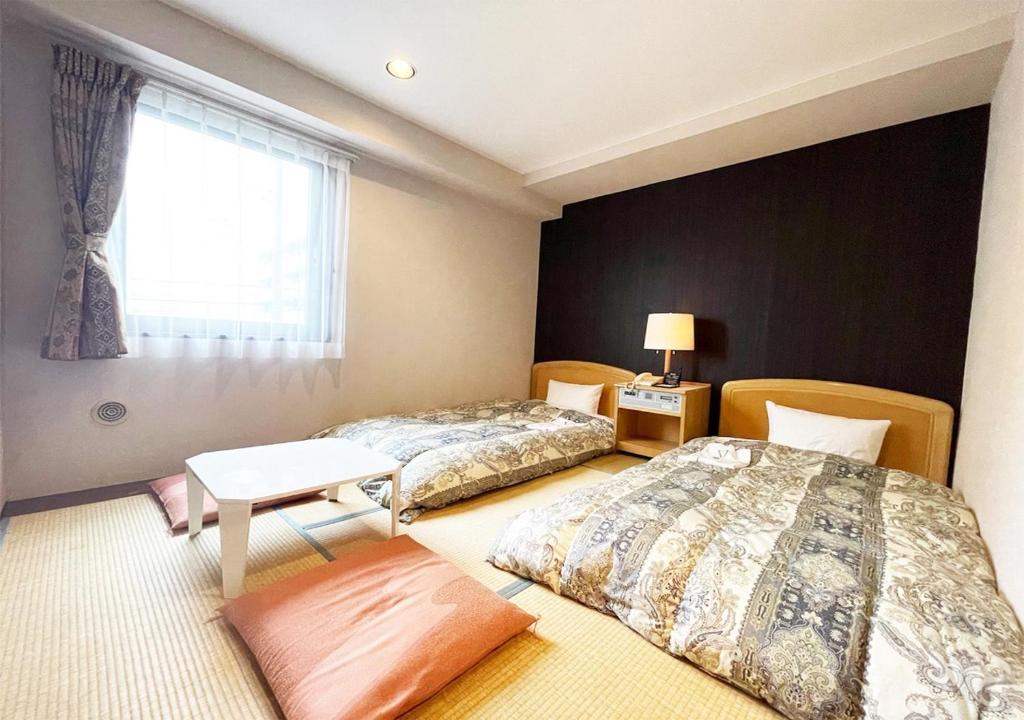 two beds in a room with a window at Hotel Royal Garden Kisarazu / Vacation STAY 72221 in Kisarazu