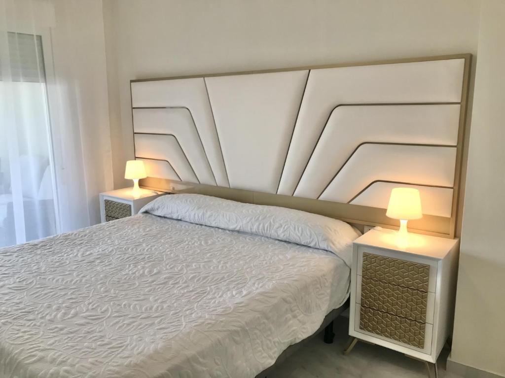 a bedroom with a white bed with two lamps at MI CAPRICHO 4C BEACHFRONT -Apartment with sea view - Costa del Sol in Sitio de Calahonda