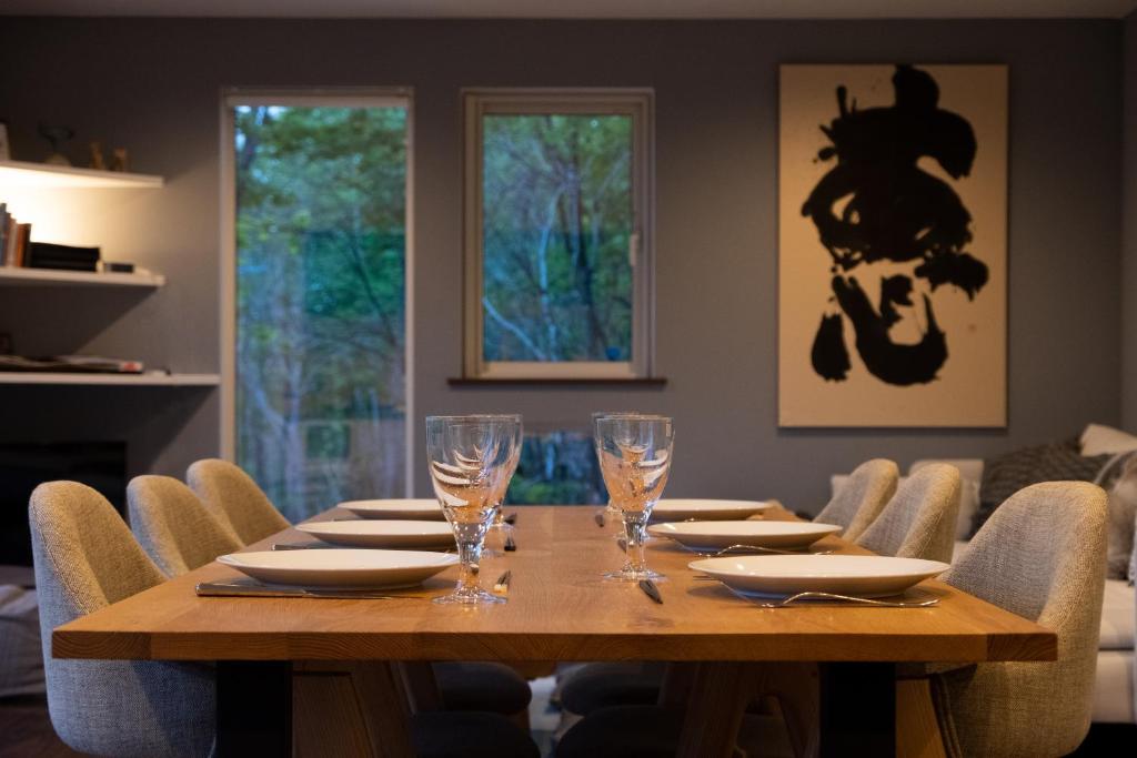 a dining room with a wooden table and chairs at Forest Hideaway in Niseko